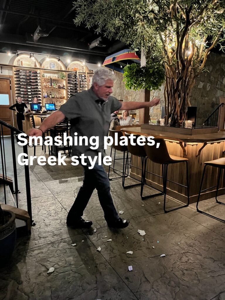 Man smashing plates in the traditional Greek style at a community celebration